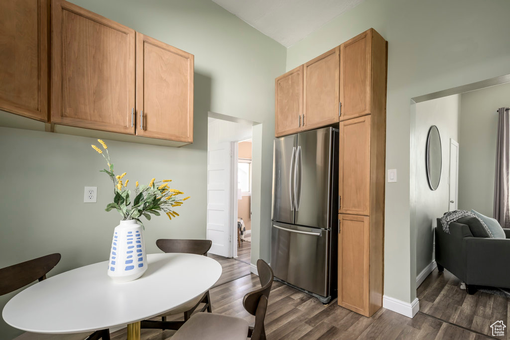 Kitchen featuring dark hardwood / wood-style flooring, light brown cabinets, and stainless steel refrigerator