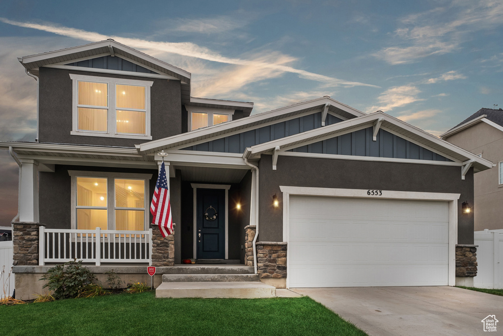 Craftsman inspired home featuring a yard, a garage, and a porch