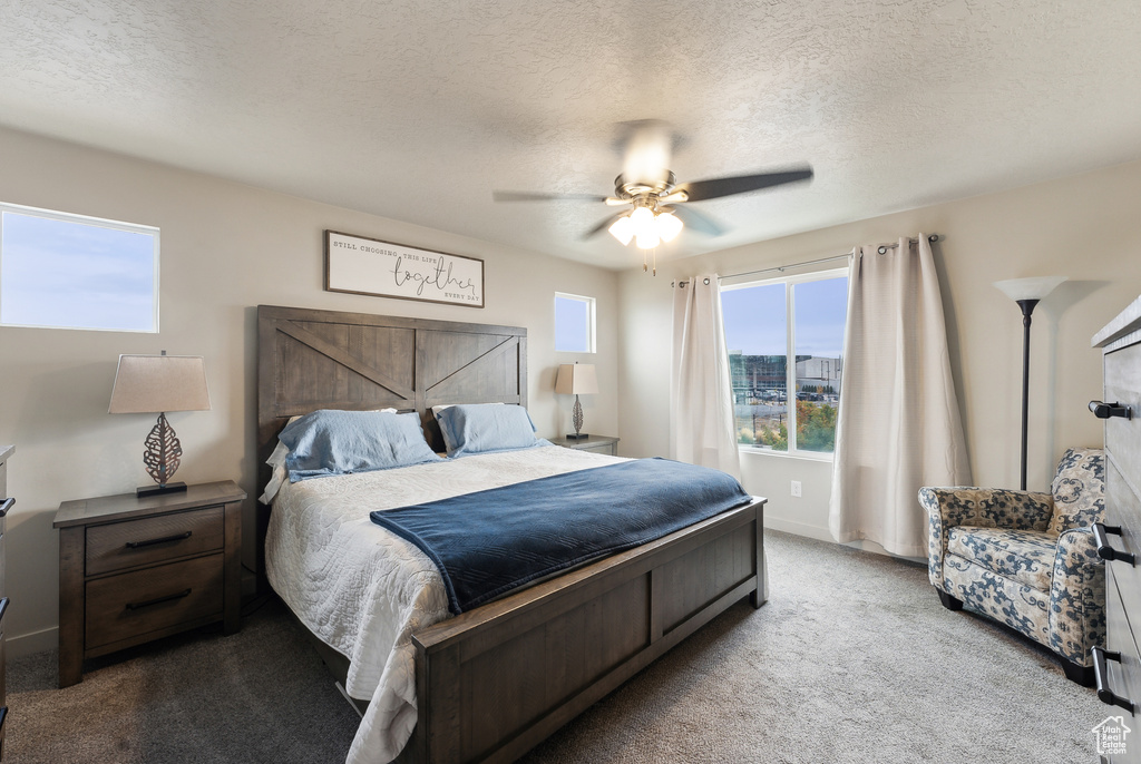 Carpeted bedroom with a textured ceiling and ceiling fan