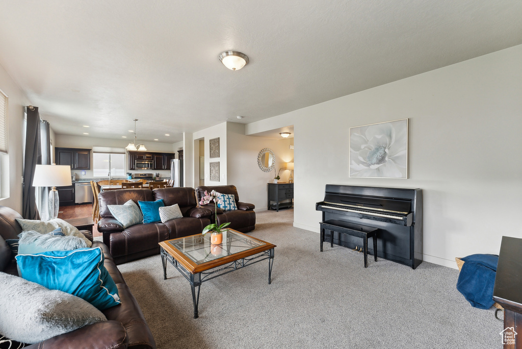 Carpeted living room with a chandelier