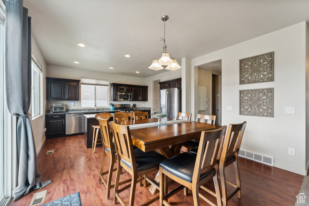 Dining room with a wealth of natural light, sink, and dark hardwood / wood-style flooring