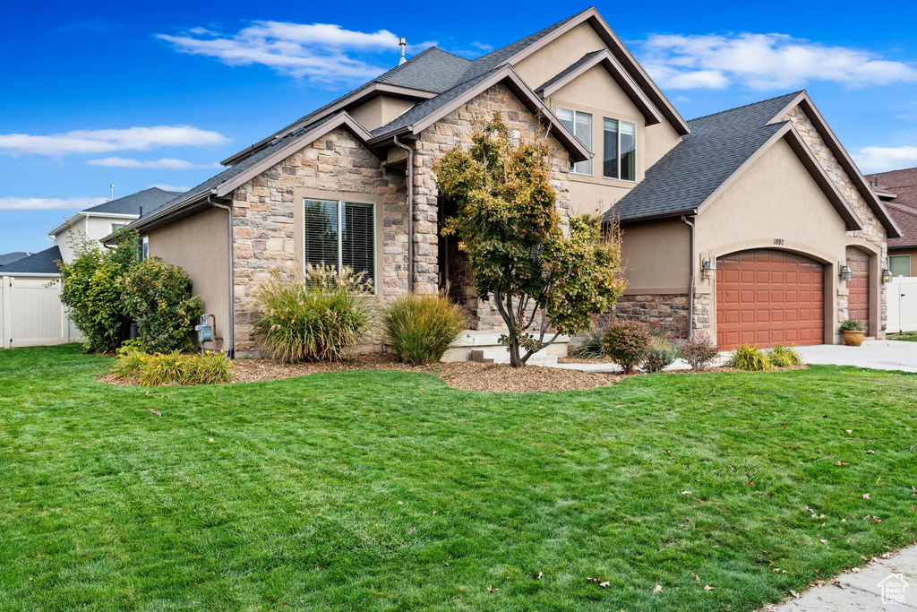 View of front of house featuring a front yard and a garage