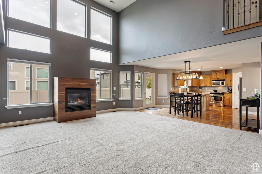 Carpeted living room with a towering ceiling