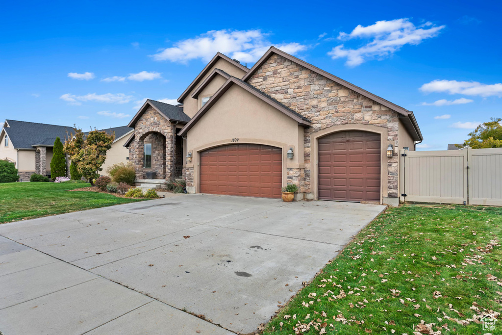 View of front of house with a front yard and a garage