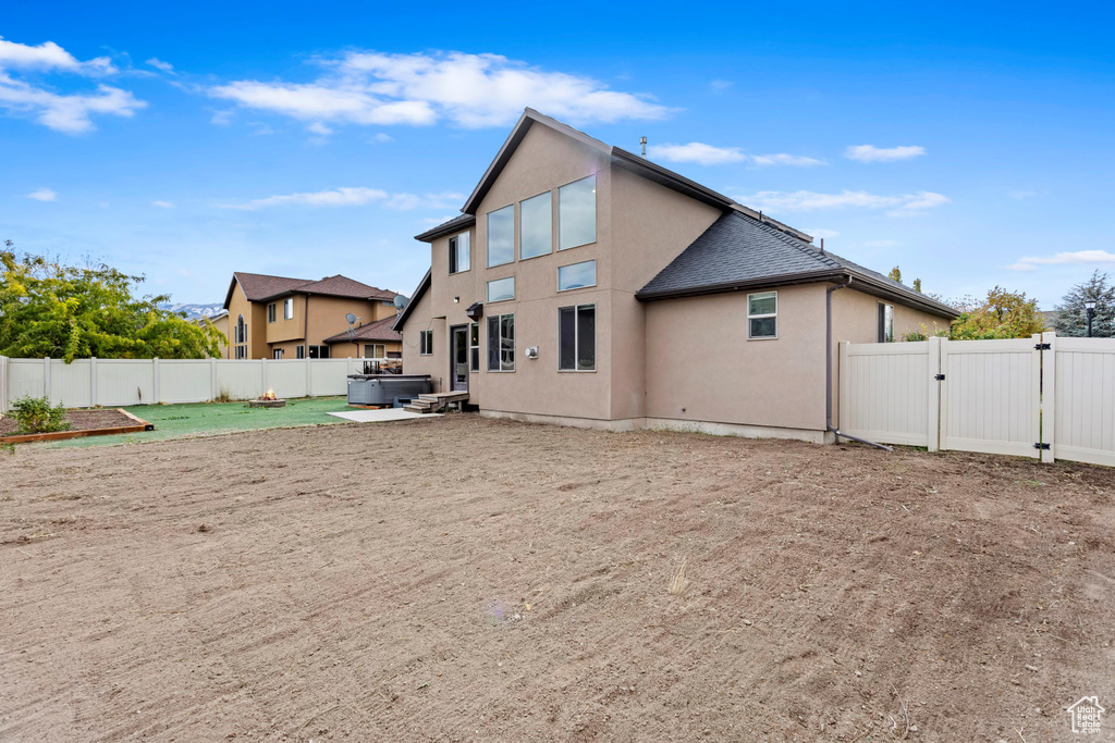 Back of property with a hot tub