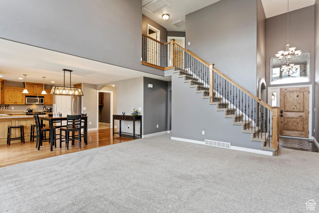 Carpeted living room with a high ceiling