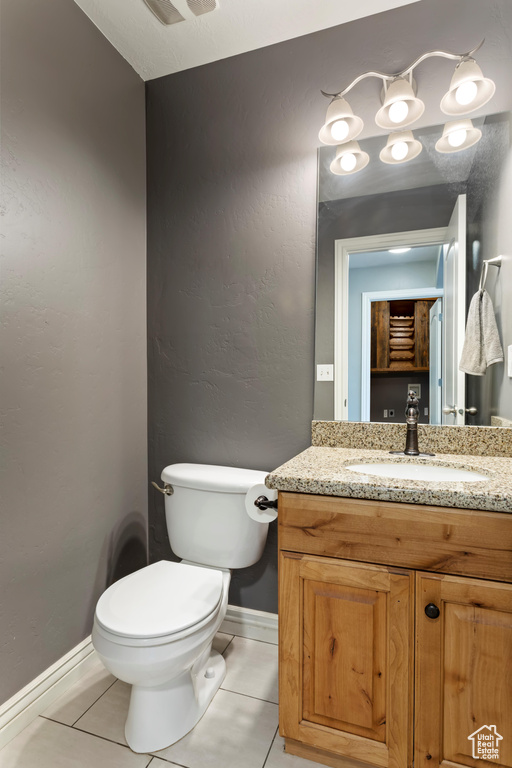 Bathroom featuring vanity, toilet, and tile patterned floors