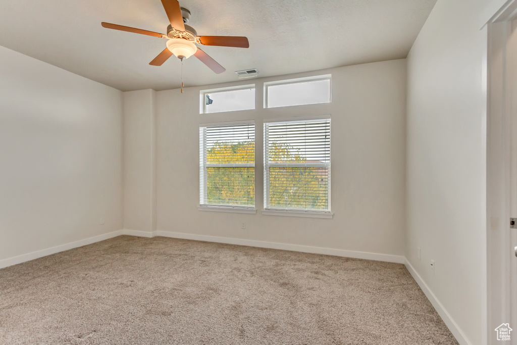 Carpeted empty room with ceiling fan