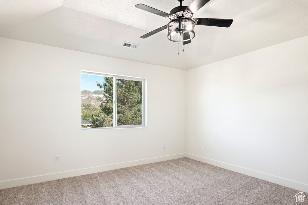 Unfurnished room with a textured ceiling, carpet floors, and ceiling fan