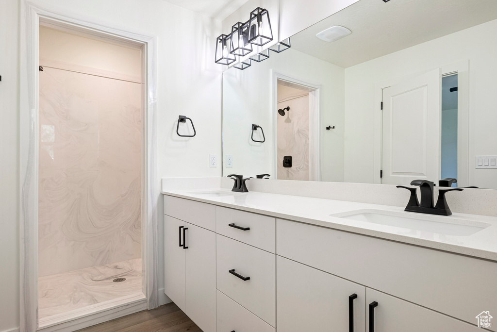 Bathroom with vanity, hardwood / wood-style flooring, and walk in shower