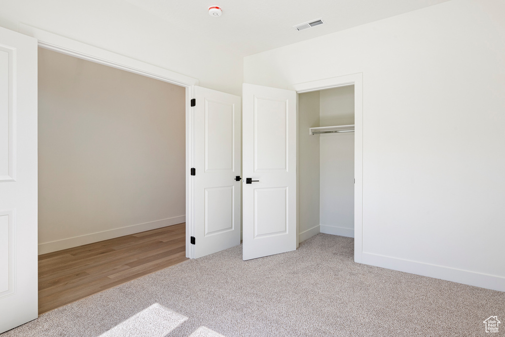 Unfurnished bedroom featuring a closet and light hardwood / wood-style floors