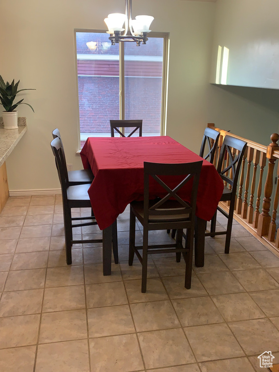 Dining space featuring a chandelier, light tile patterned floors, and baseboards
