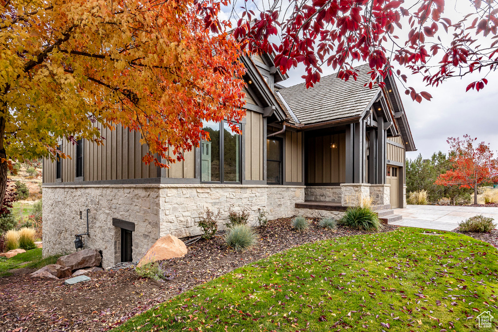 View of property exterior with a garage and a lawn