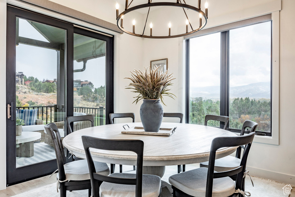 Dining area with light hardwood / wood-style floors and an inviting chandelier