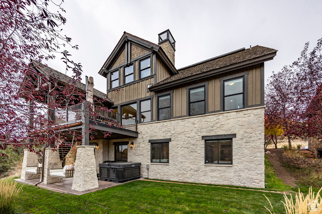 Rear view of house with a yard and a patio