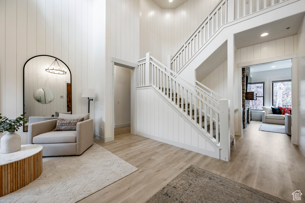 Interior space with wooden walls, hardwood / wood-style flooring, and a towering ceiling