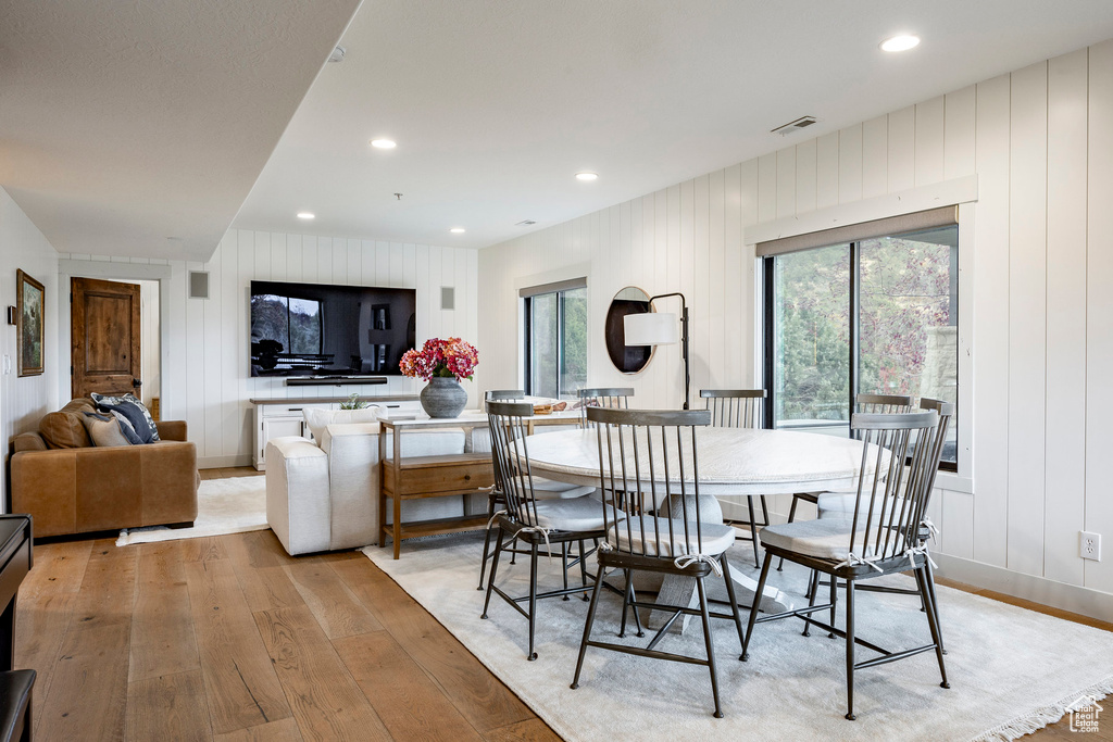 Dining area featuring light hardwood / wood-style floors and wooden walls