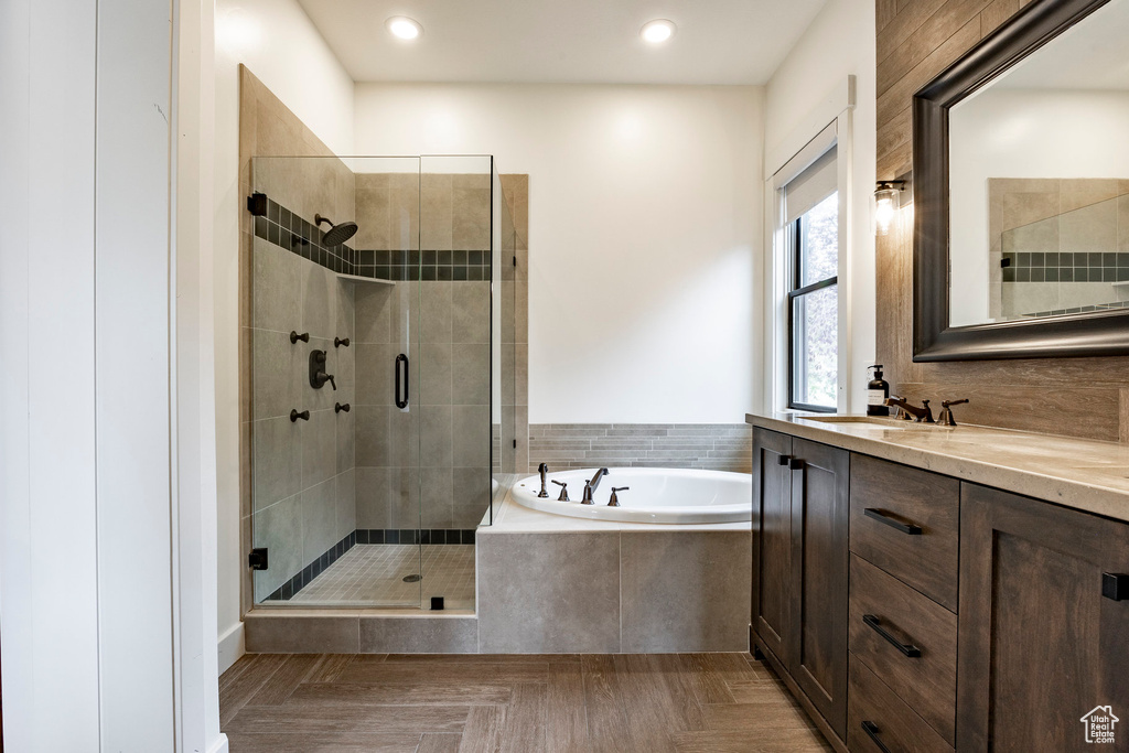 Bathroom with vanity, parquet floors, and plus walk in shower