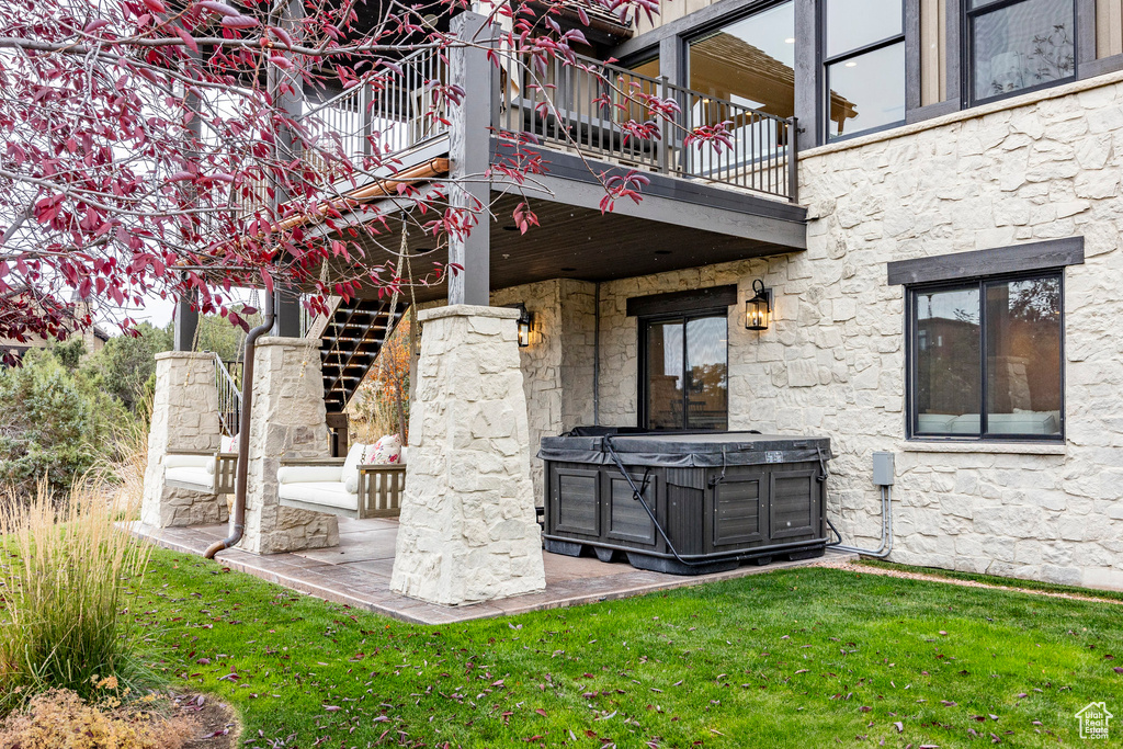 View of patio / terrace with a hot tub and a balcony