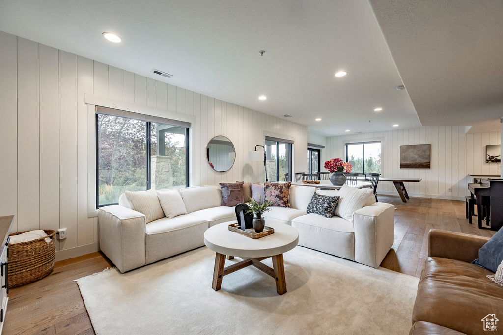 Living room featuring wooden walls and light hardwood / wood-style flooring