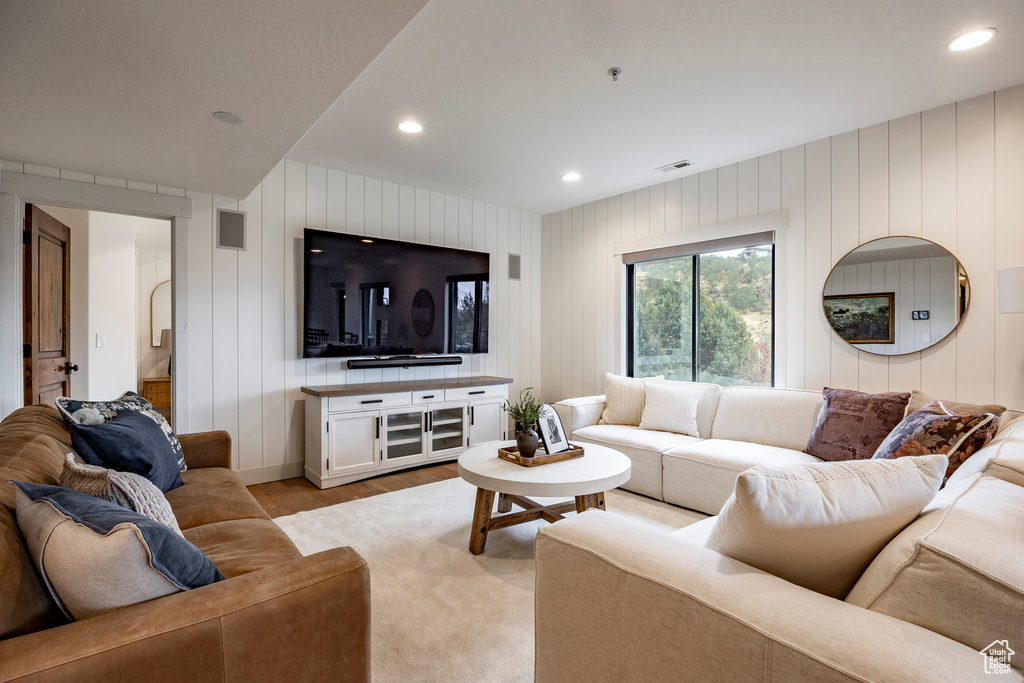 Living room with wooden walls and light wood-type flooring