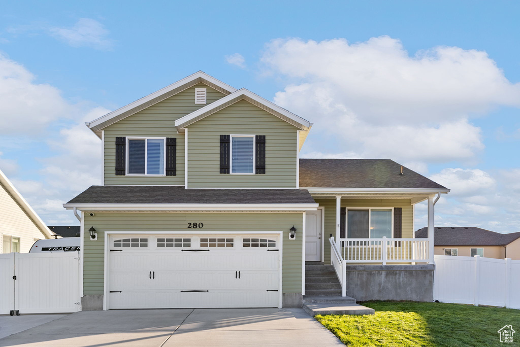 View of front of house featuring a garage and covered porch