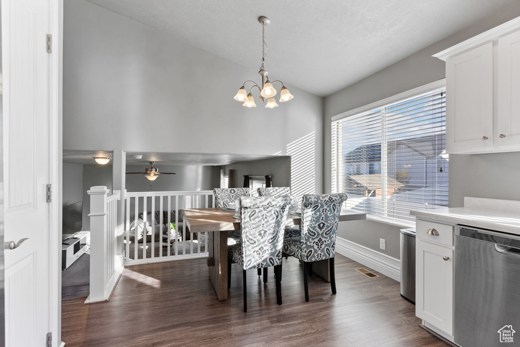 Dining room featuring ceiling fan with notable chandelier and dark hardwood / wood-style flooring