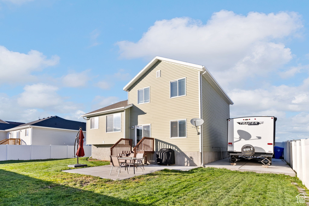 Rear view of house featuring a yard and a patio