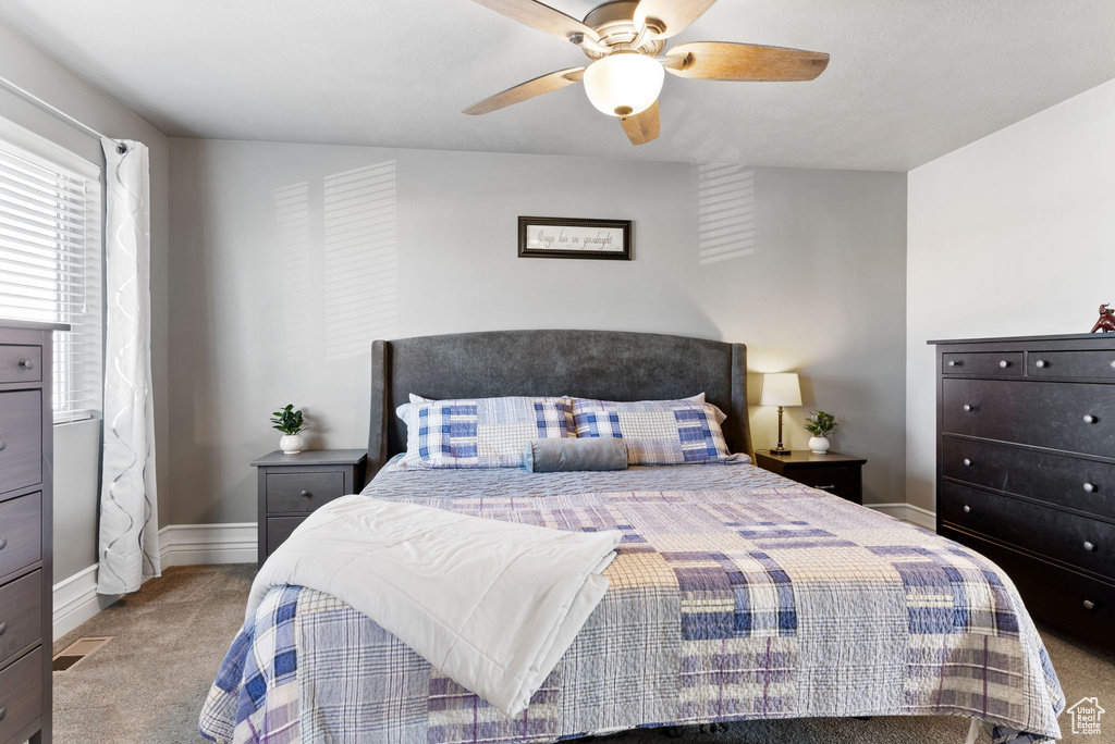 Carpeted bedroom featuring ceiling fan