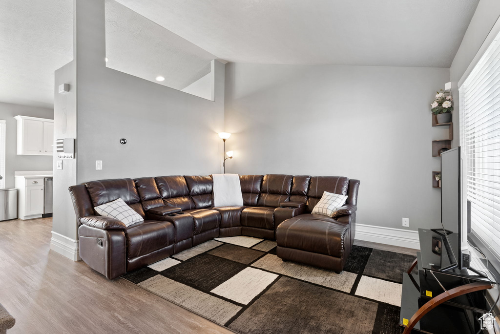 Living room featuring lofted ceiling and light hardwood / wood-style flooring