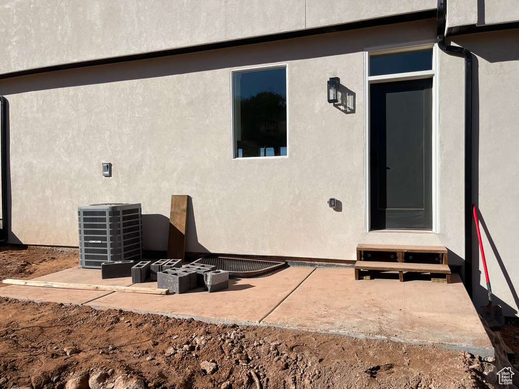 Property entrance featuring central air condition unit and a patio area