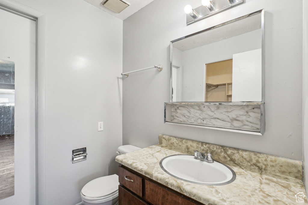 Bathroom with vanity, toilet, and hardwood / wood-style floors