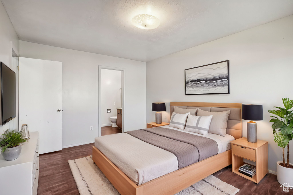 Bedroom featuring connected bathroom and dark hardwood / wood-style flooring