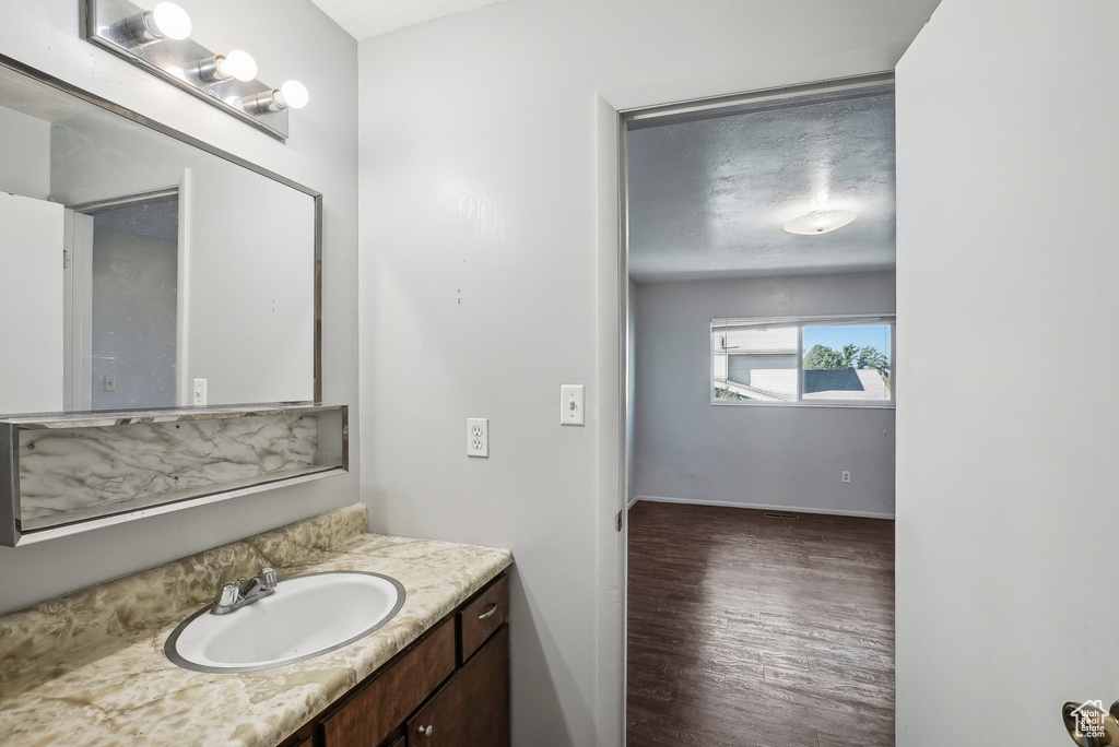 Bathroom featuring vanity, hardwood / wood-style flooring, and a textured ceiling