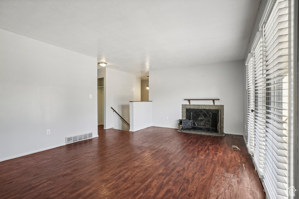 Unfurnished living room with dark wood-type flooring