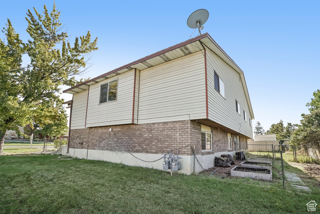 View of home's exterior with a yard and central AC unit