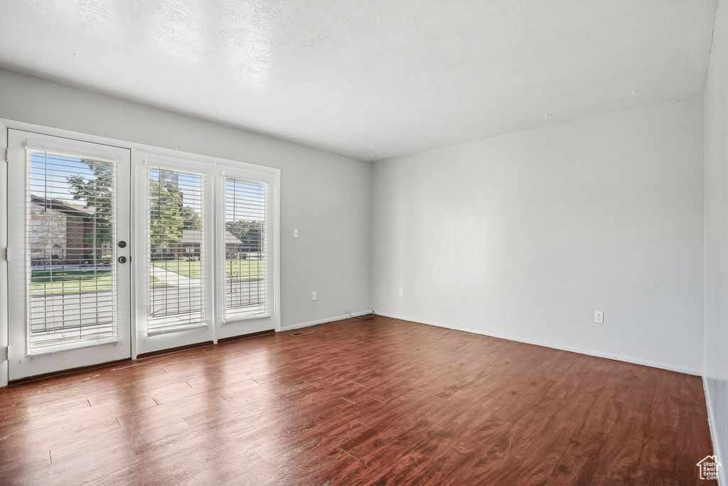 Spare room with a textured ceiling and hardwood / wood-style floors