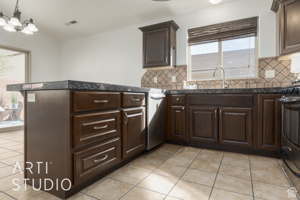 Kitchen featuring kitchen peninsula, stainless steel appliances, backsplash, and light tile patterned floors