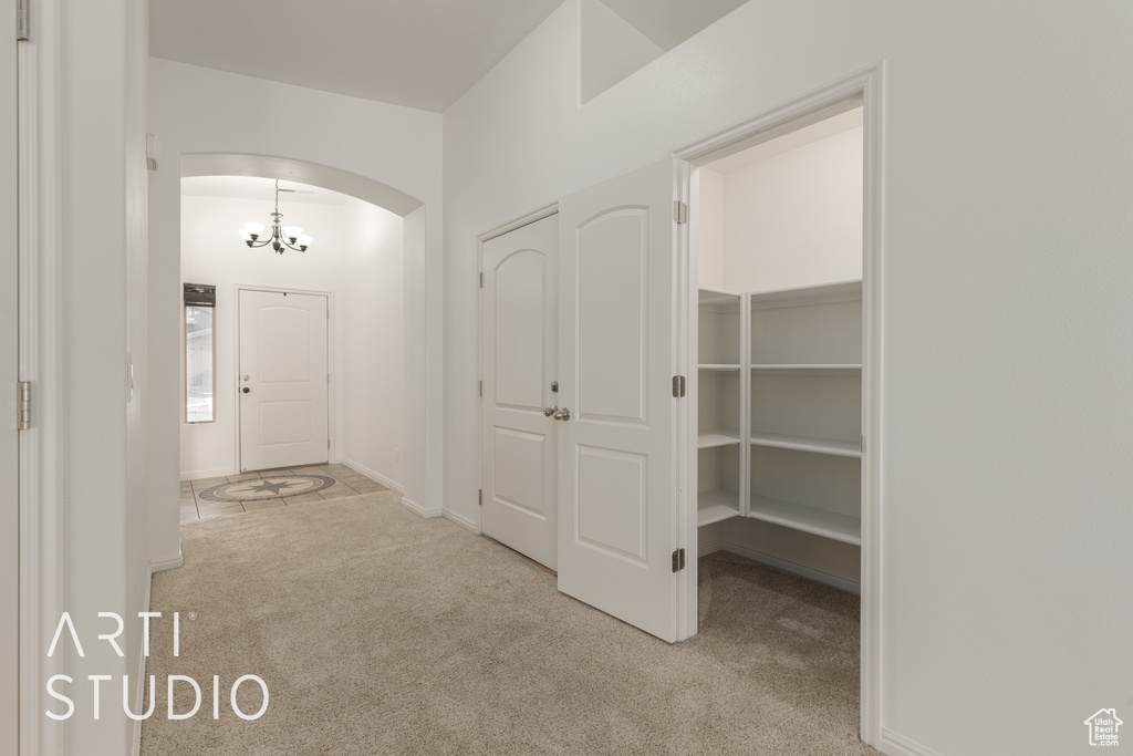 Hallway featuring light colored carpet