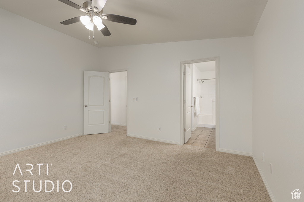 Unfurnished bedroom with connected bathroom, ceiling fan, and light carpet