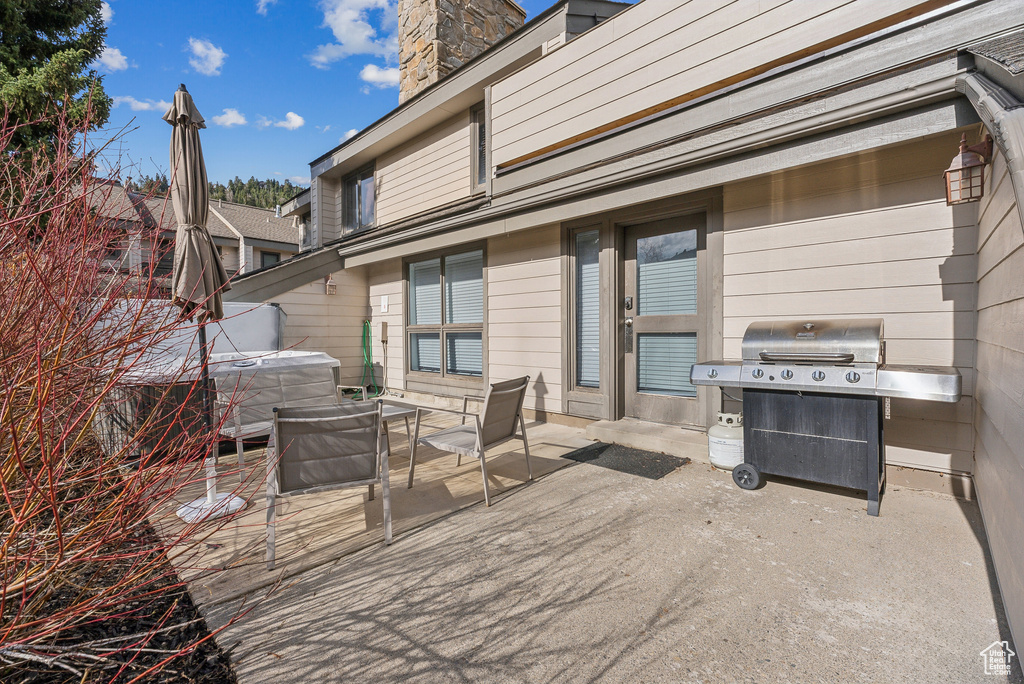 View of patio / terrace with a hot tub and a grill