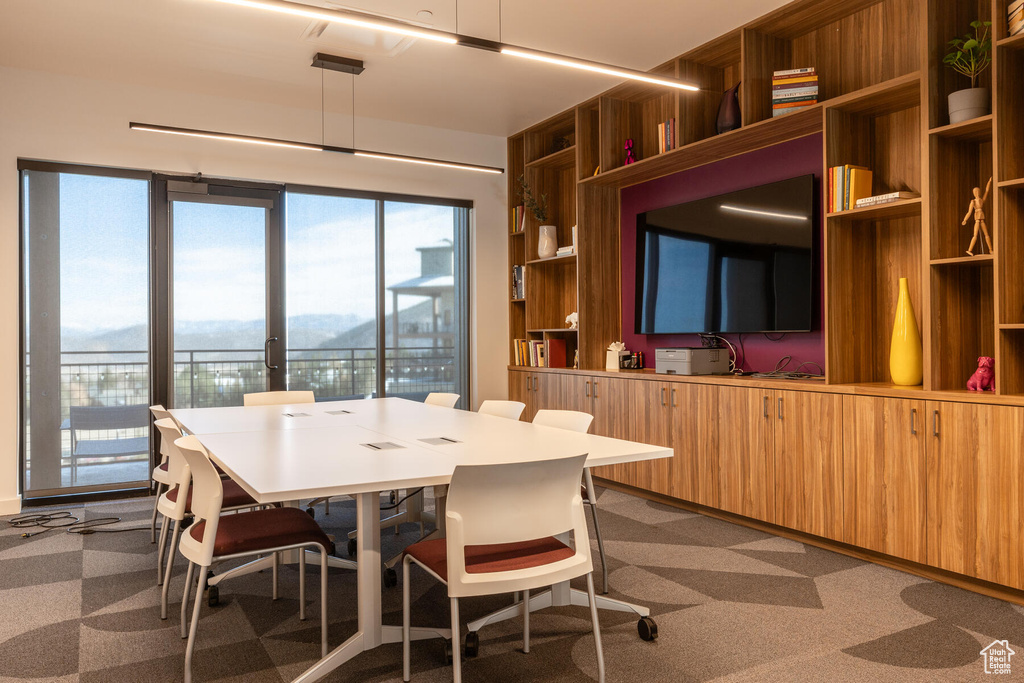 Dining room with built in features, wooden walls, and carpet