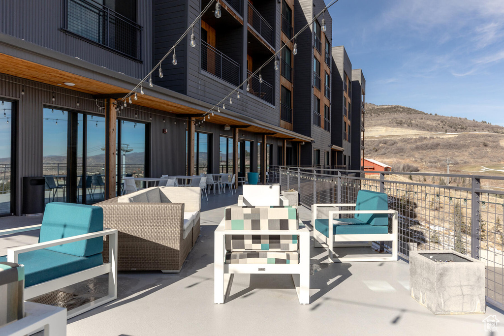 View of patio featuring a balcony, outdoor lounge area, and a mountain view