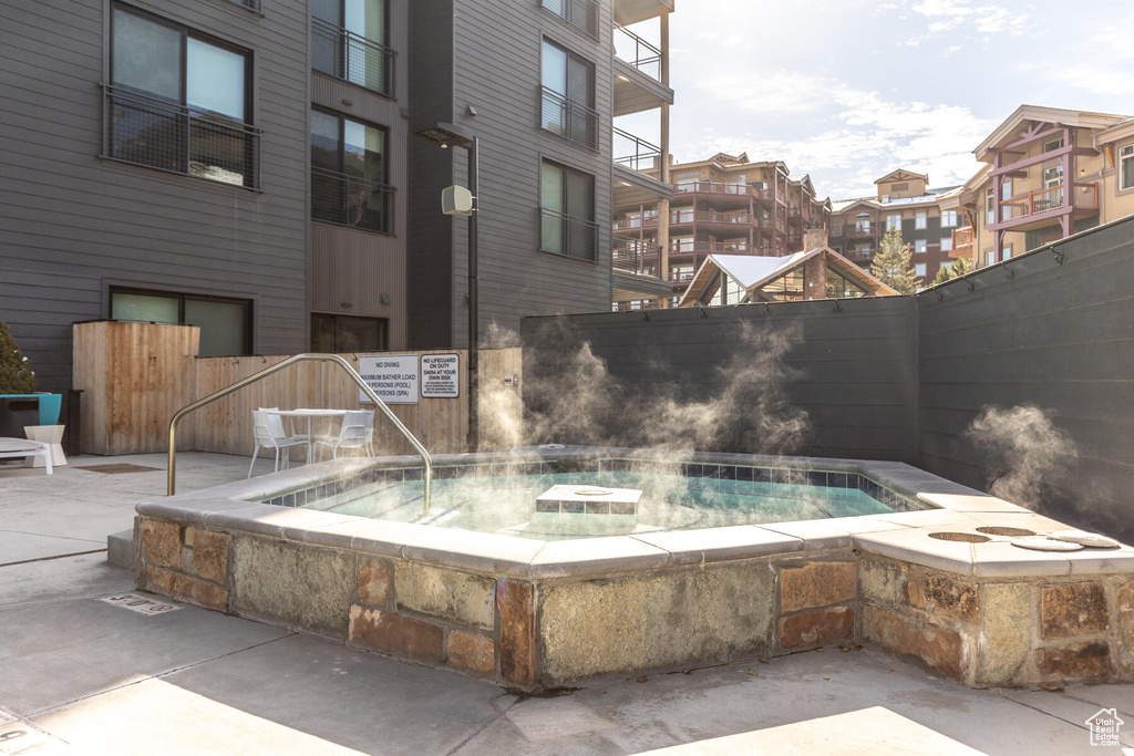 View of swimming pool with a patio and a community hot tub