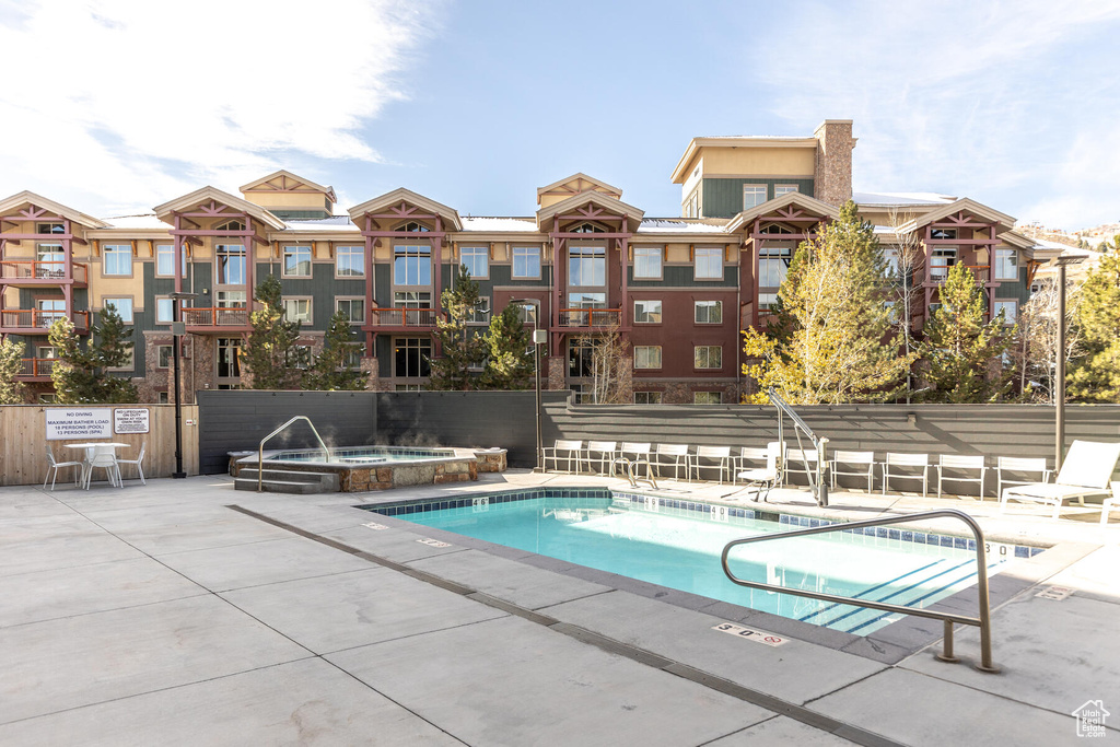 View of pool with a patio area and a community hot tub