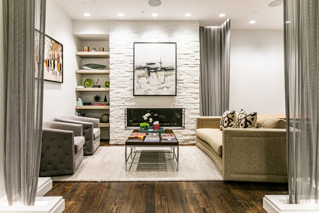 Living room featuring a fireplace, dark hardwood / wood-style floors, and built in shelves