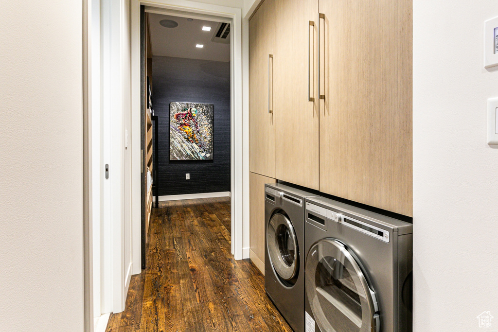 Clothes washing area with dark hardwood / wood-style floors