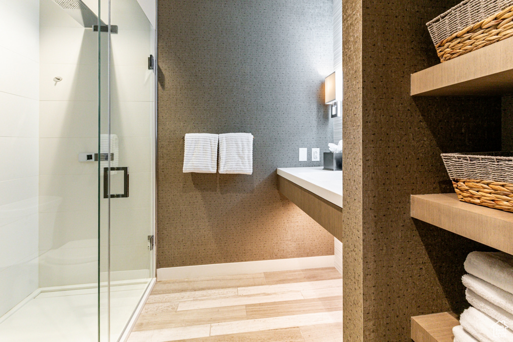 Bathroom with an enclosed shower and wood-type flooring