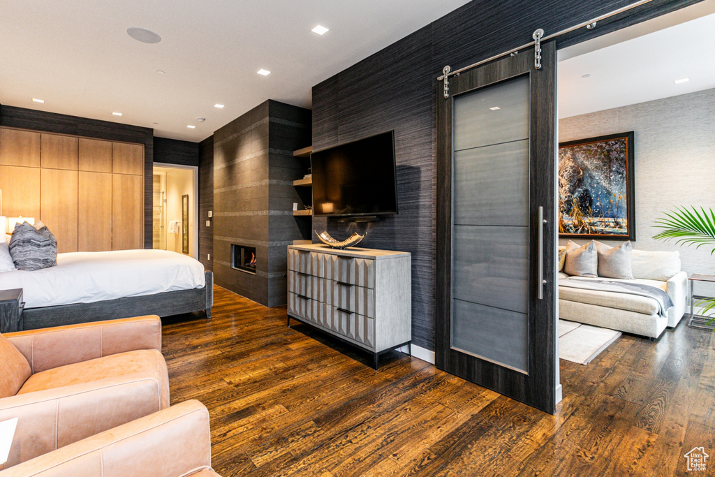 Bedroom featuring dark hardwood / wood-style floors and a barn door