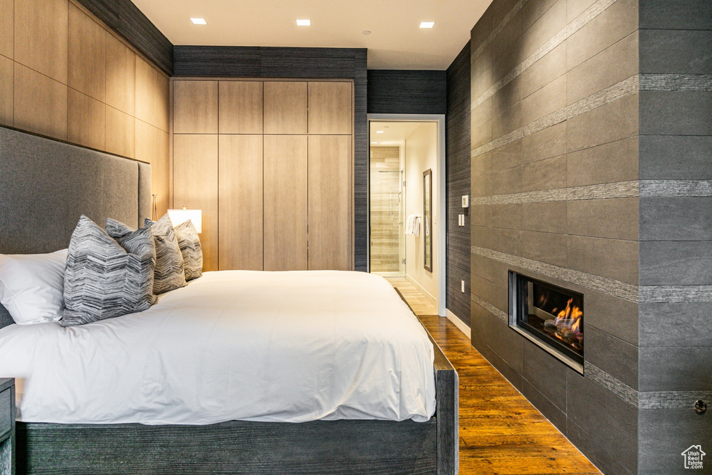 Bedroom featuring a fireplace and dark hardwood / wood-style floors